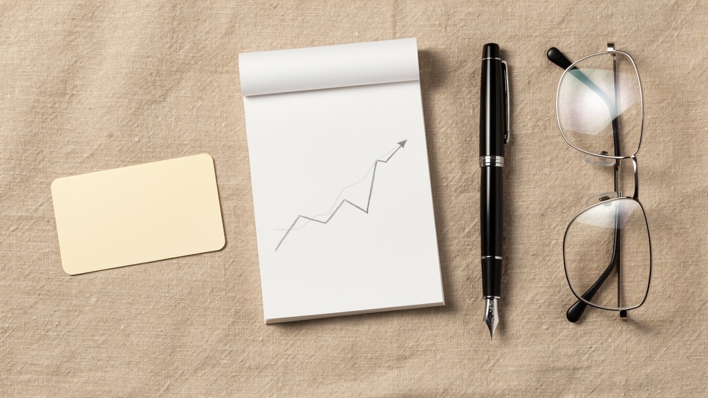 A notepad with a hand-drawn chart, pen and blank payment card on beige linen